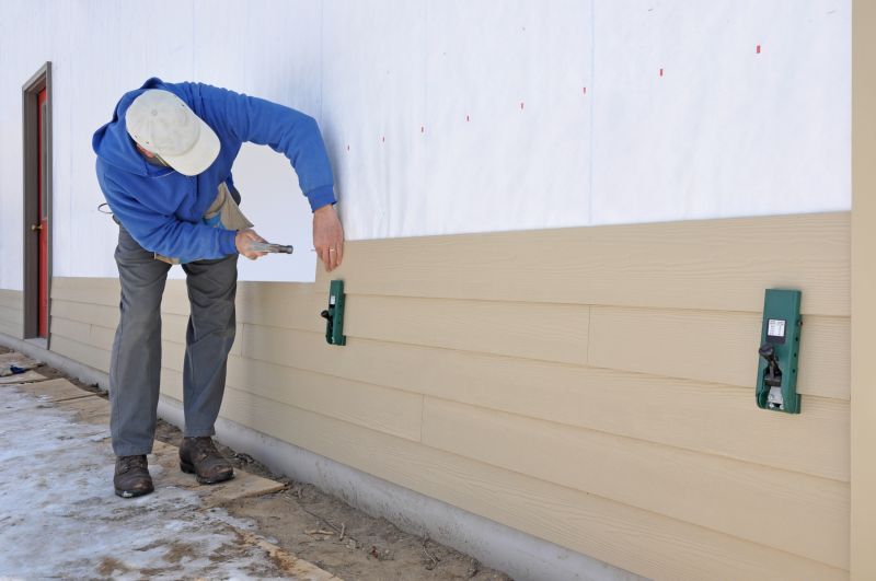 Workers applying fiber cement siding